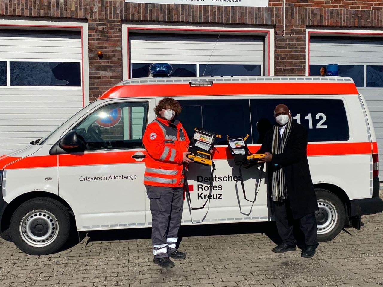 Pastor Dr. Rogers Biriija und stellvertretenden Rotkreuzleiter Daniel Möllers bei der Übergabe der Geräte.